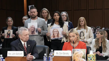 Epstein survivors and family members stand behind former Attorney General John Ashcroft and Jeffrey Epstein survivor Dani Bensky as she speaks during the second day of acting Attorney General Todd Blanche’s Senate Judiciary Committee confirmation hearing on July 16.