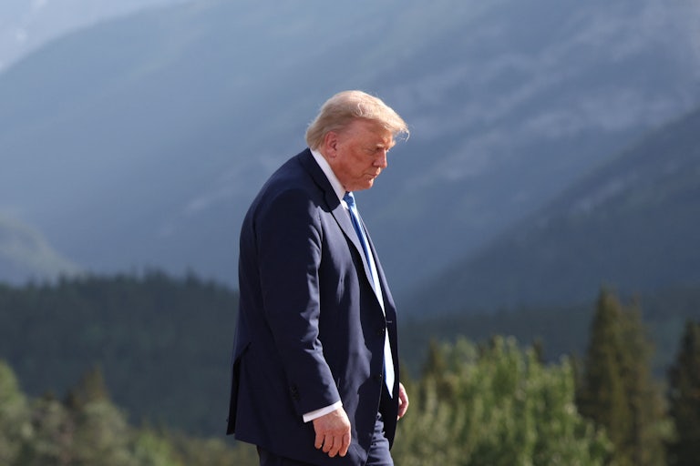 Donald Trump looks down while walking at the G7 meeting in Canada