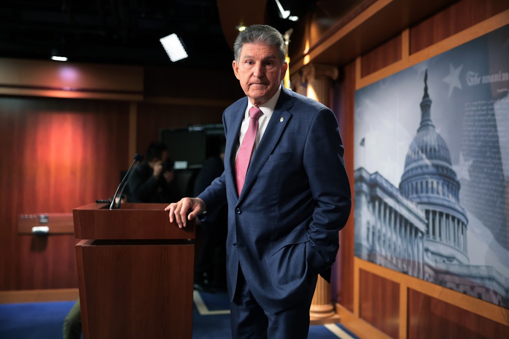 Senator Joe Manchin shoots a glance offstage as he talks to reporters at the U.S. Capitol.