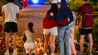 People stand in front of a memorial for shooting victims at Florida State University