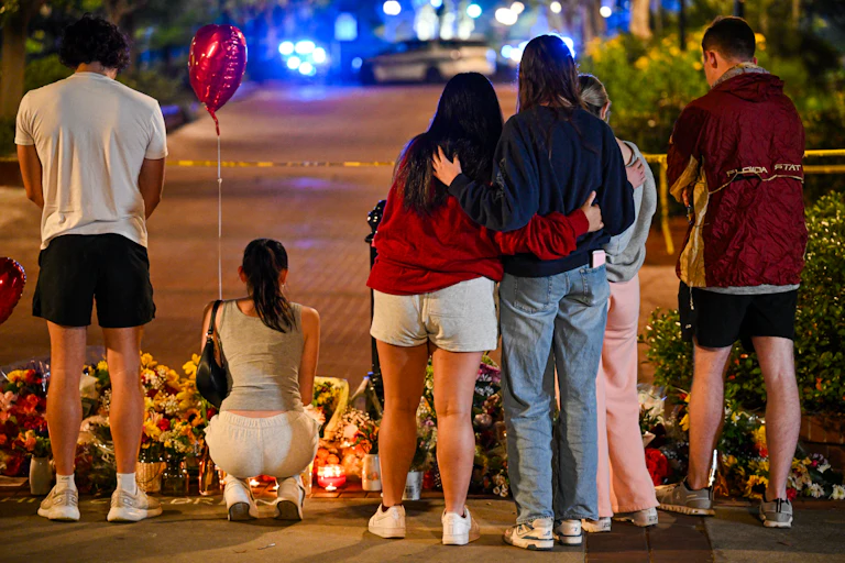 People stand in front of a memorial for shooting victims at Florida State University