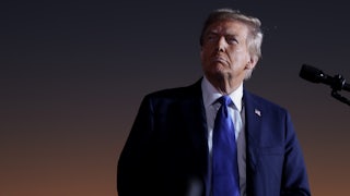 Donald Trump looks up while standing at a podium