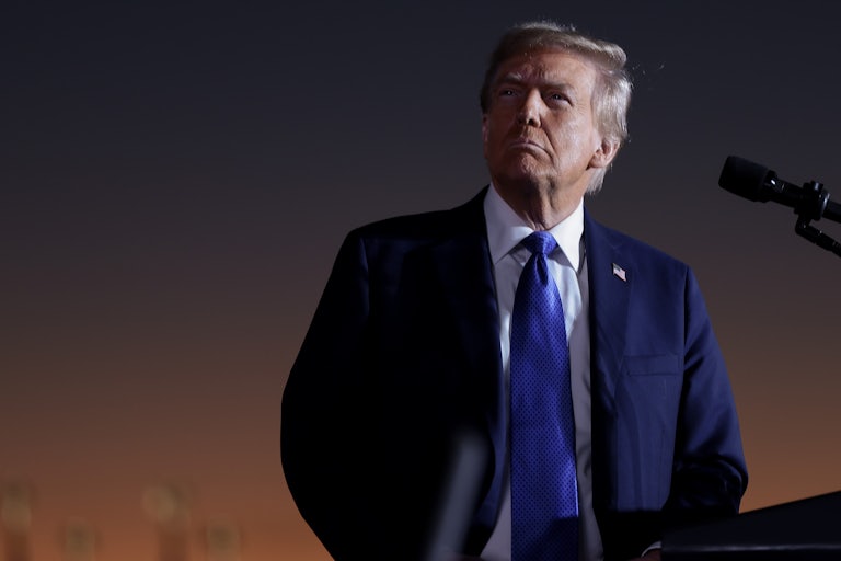 Donald Trump looks up while standing at a podium