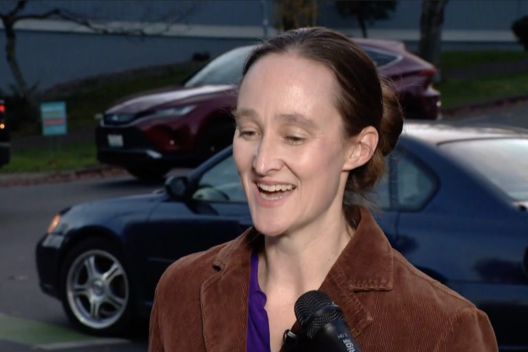 Katie Wilson smiles while being interviewed on the street.