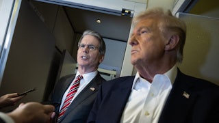 Treasury Secretary Scott Bessent stands next to Donald Trump while speaking to reporters on Air Force One