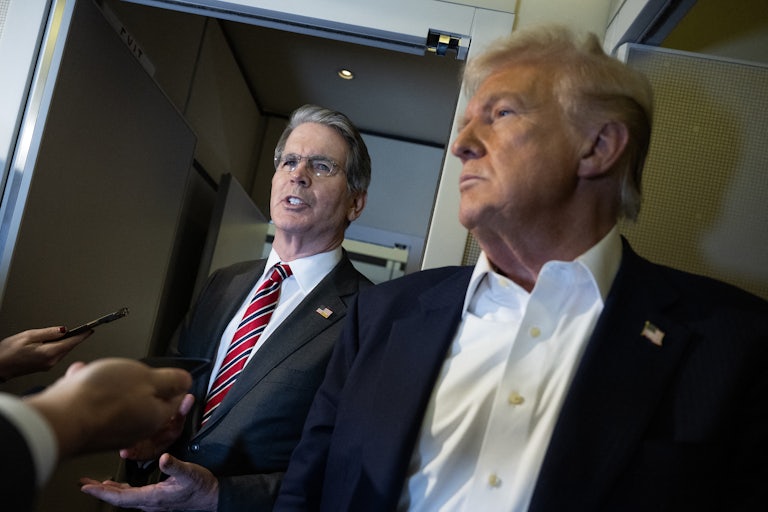 Treasury Secretary Scott Bessent stands next to Donald Trump while speaking to reporters on Air Force One