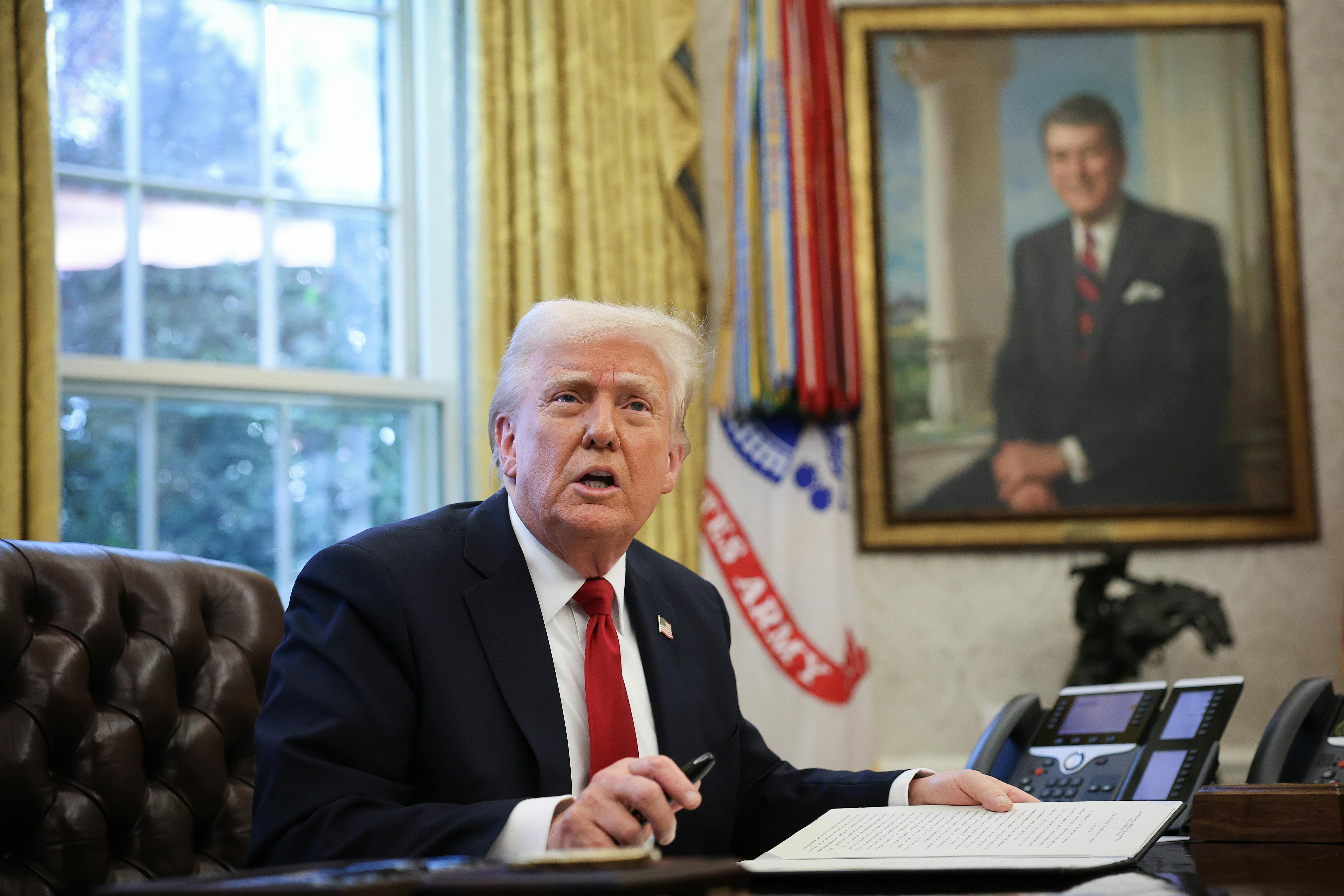 Donald Trump speaks to the press before signing an executive order in the Oval Office.