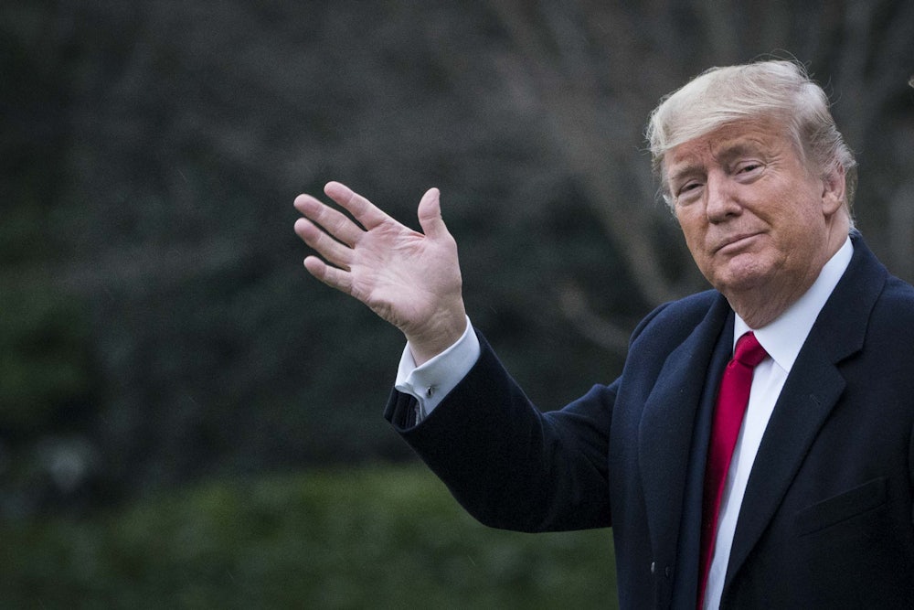 President Donald Trump waves at a camera.