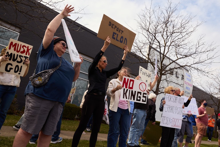 People protest against Elon Musk outside a Tesla dealership in Columbus, Ohio