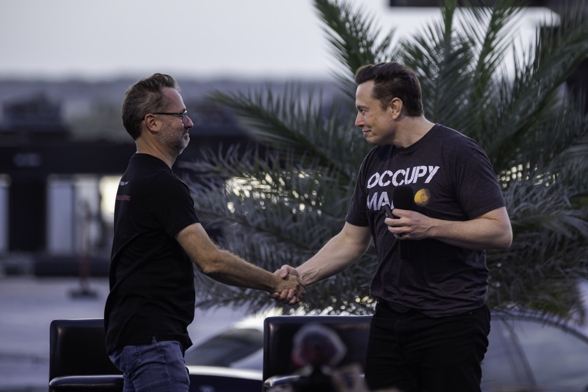 T-Mobile CEO Mike Sievert shakes the hand of Tesla's Elon Musk at an event in Boca Chica Beach, Texas.