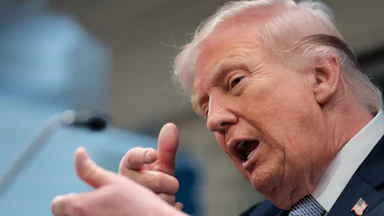 President Donald Trump speaks and makes a hand gesture as if he's about to shoot someone with a sniper.