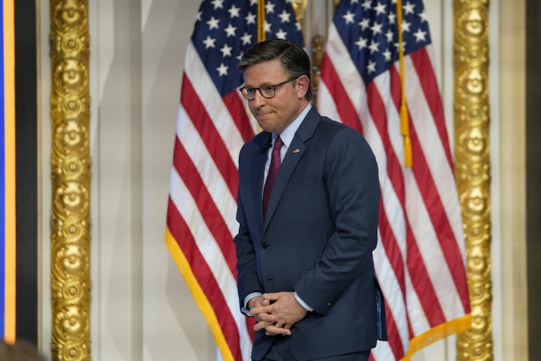 Mike Johnson stands with his hands folded in front of him