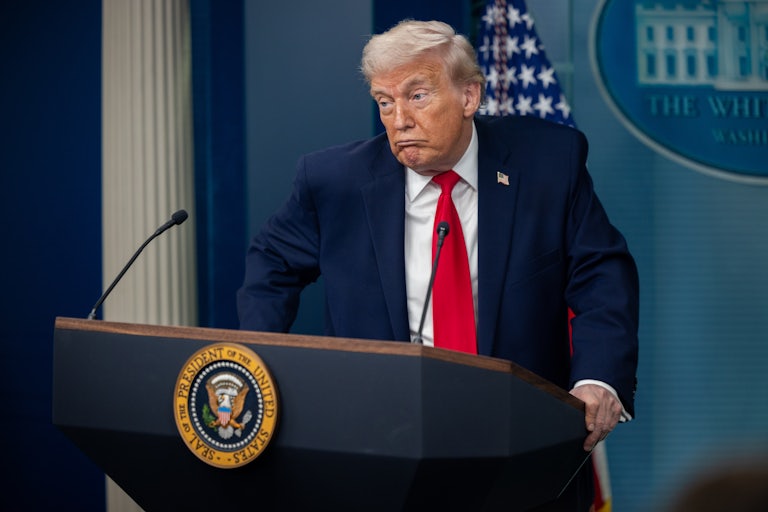 Donald Trump makes a face while standing at the podium in the White House press briefing room