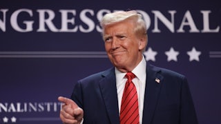 Donald Trump smiles and points his finger (presumably to someone in the crowd, not pictured)