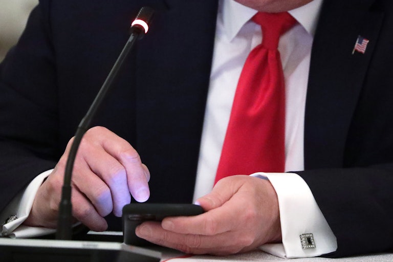 Trump posts something on his cellphone. (His head is cut off in this frame.)