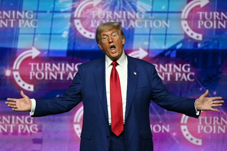 Donald Trump holds his arms out while speaking at a campaign event
