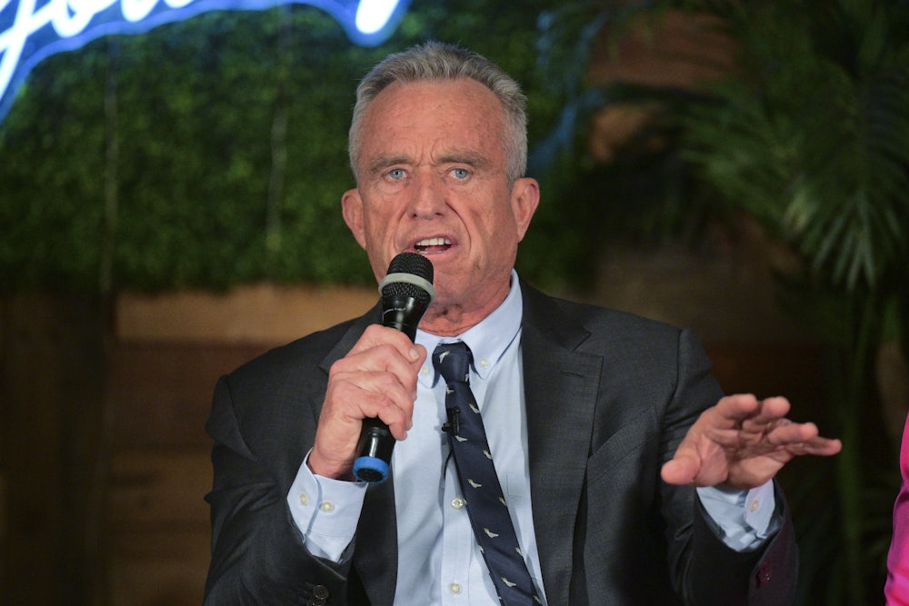 RFK Jr. holds a microphone and speaks.