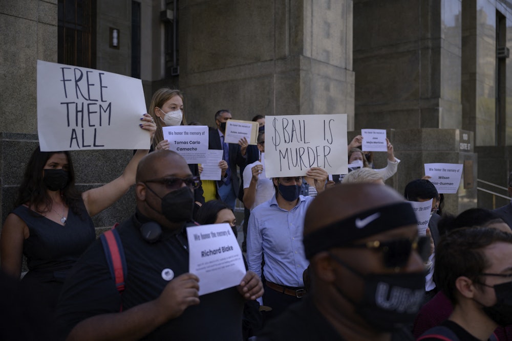 Activists stand outside the Manhattan Criminal Court holding placards about bail