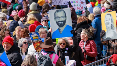People hold up portraits of Alex Pretti and Renee Nicole Good during the No Kings protest in Minneapolis, Minnesota