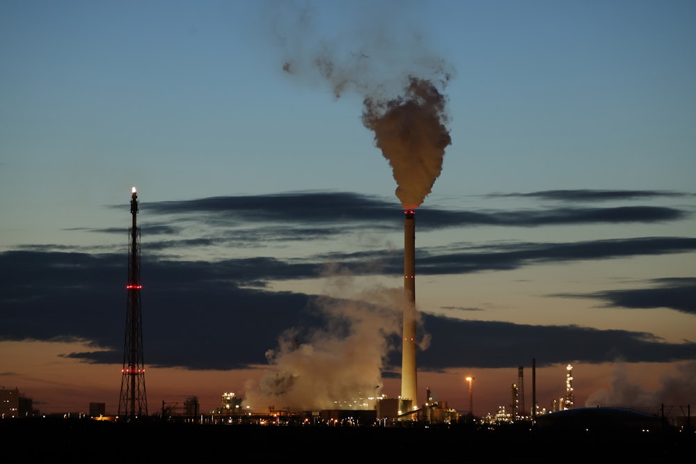 Smoke rises from refinery towers.