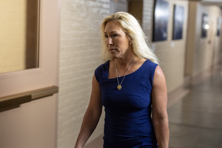 Representative Marjorie Taylor Greene looks down while walking in the Capitol