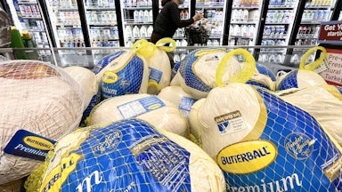A shopper walks past turkeys displayed for sale in a grocery store ahead of the Thanksgiving holiday.
