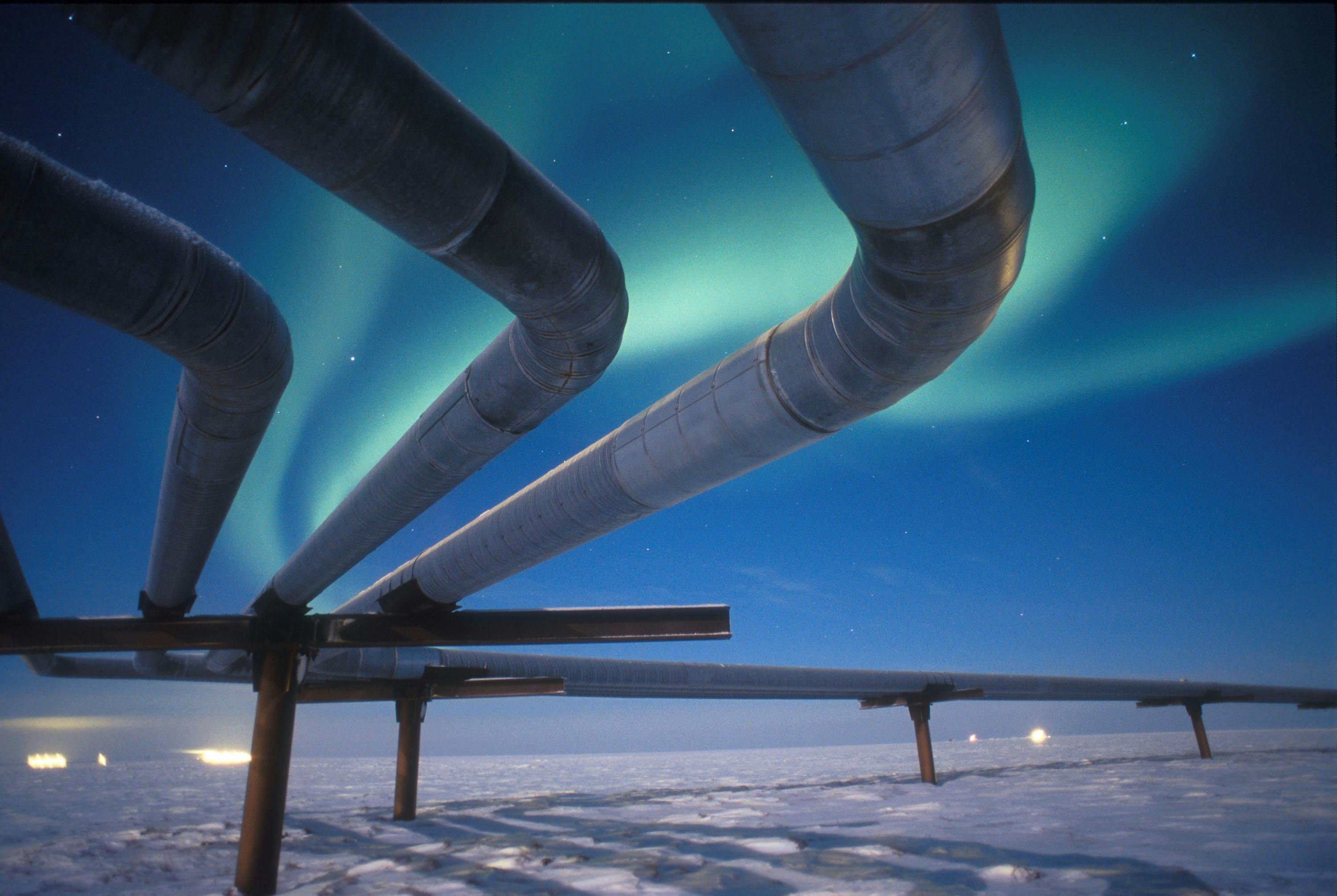 The Alaskan pipeline appears beneath the Aurora Borealis near Milne Point, Alaska.