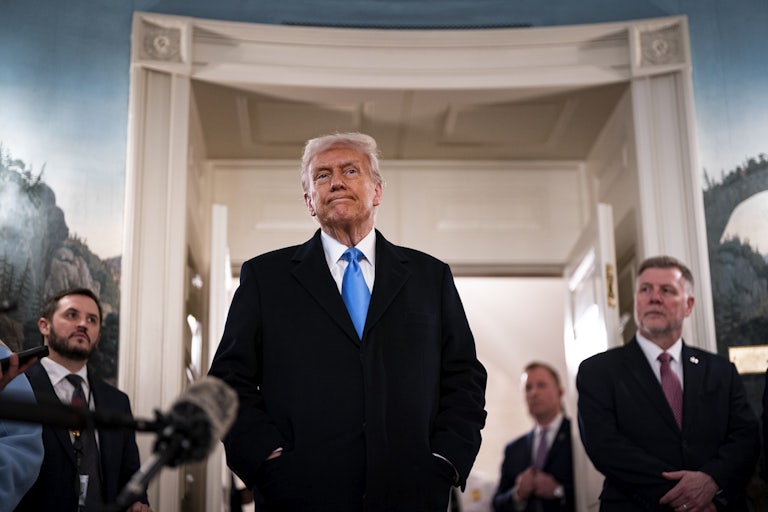 Donald Trump stands and speaks to reporters