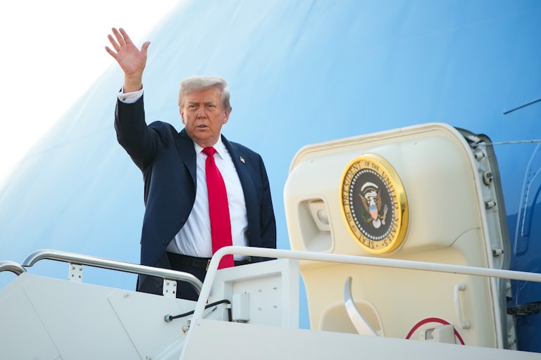 Donald Trump waves while boarding Air Force One