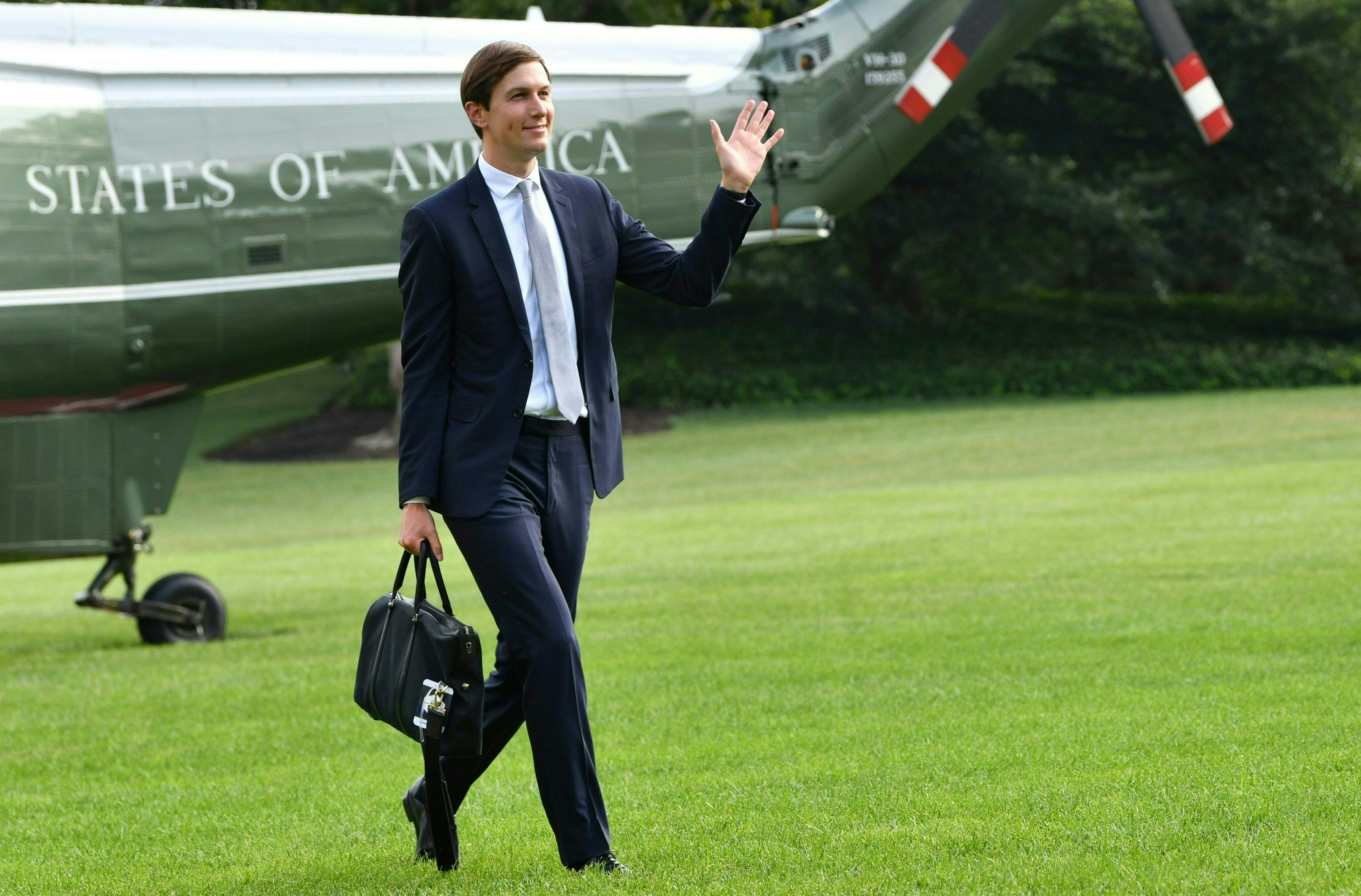 Jared Kushner waves as he returns to the White House