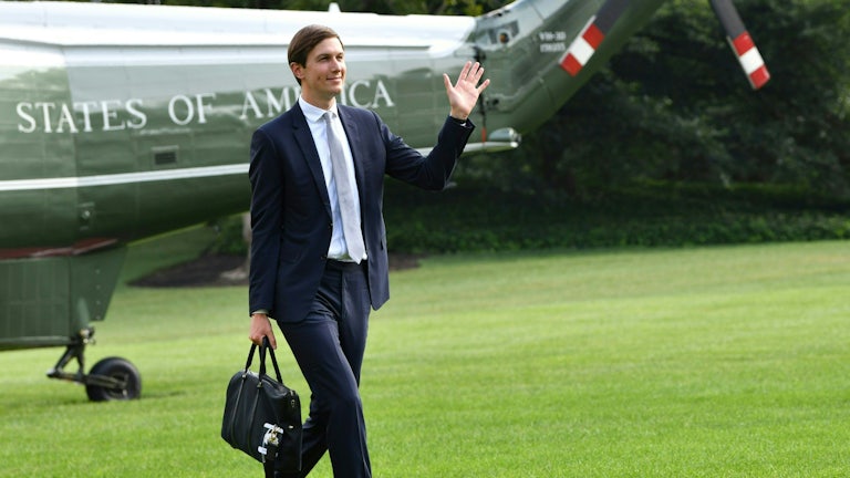 Jared Kushner waves as he returns to the White House