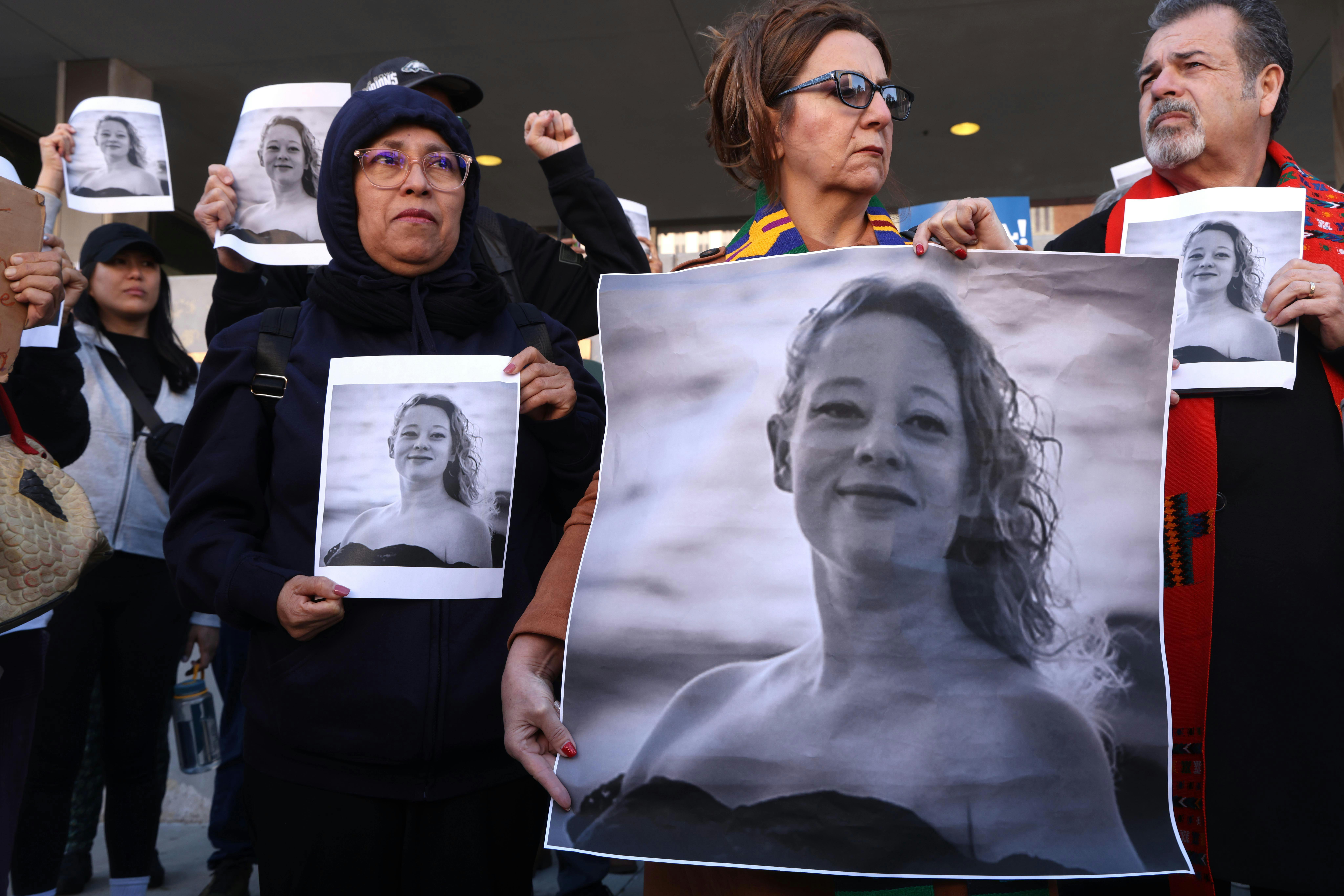 Protesters hold photos of Renee Nicole Good