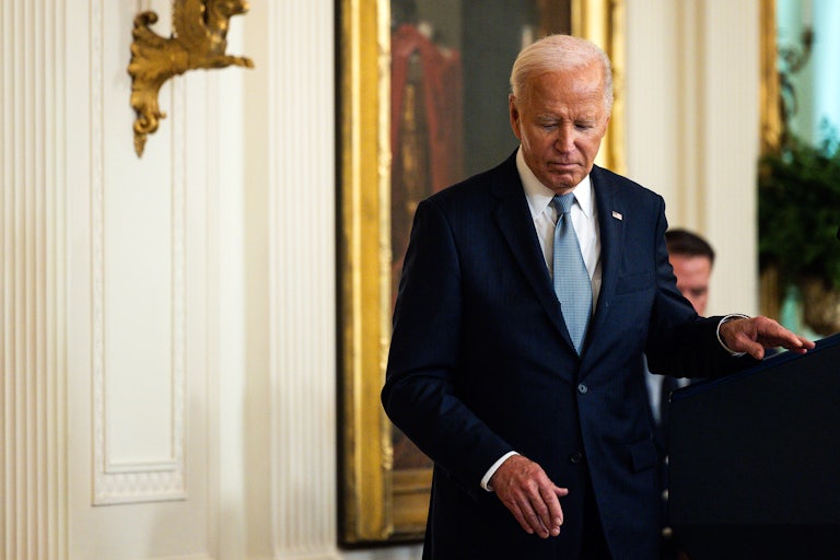 Joe Biden leaves the podium looking downcast.