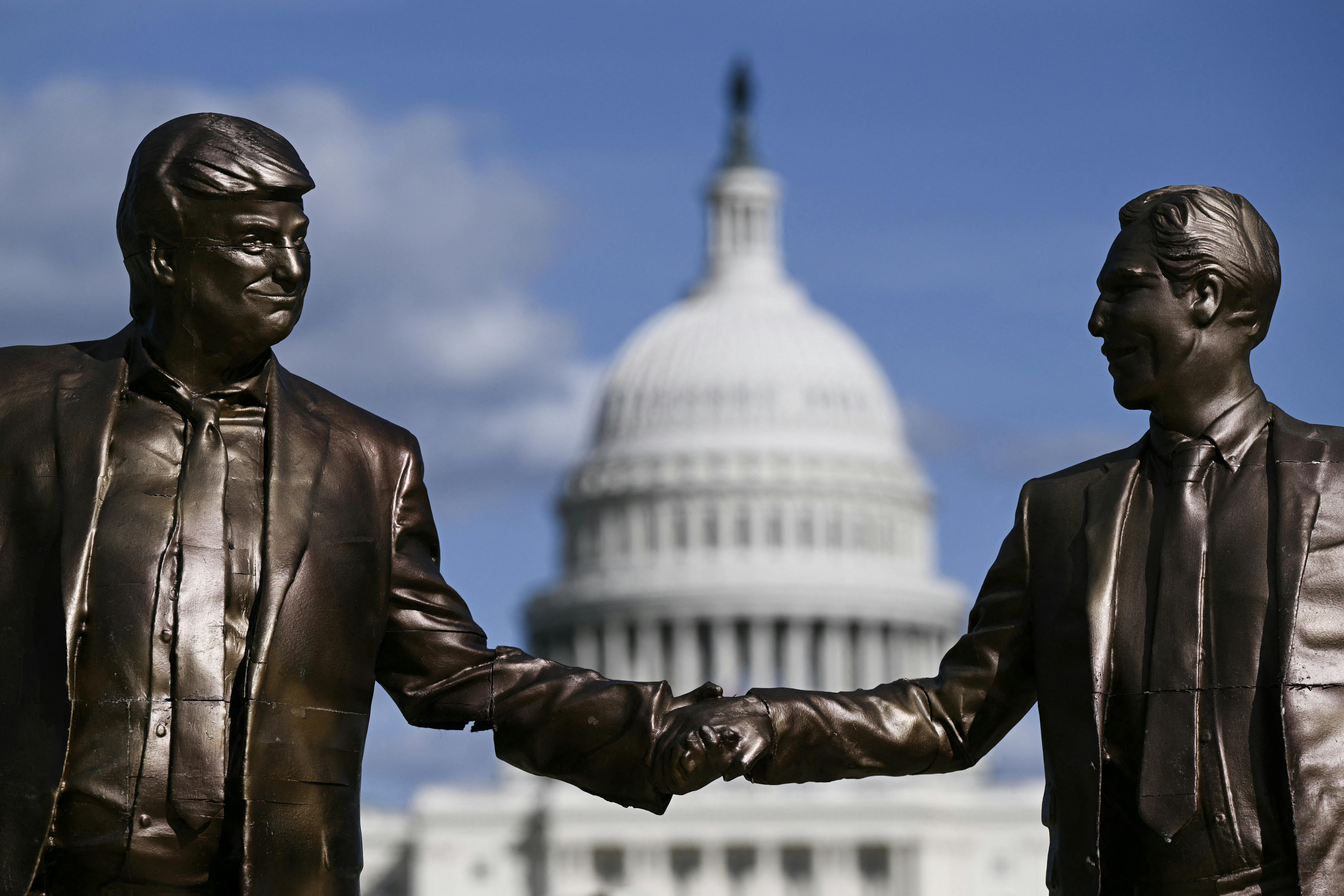 A statue of Donald Trump and Jeffrey Epstein holding hands stands in front of the Capitol