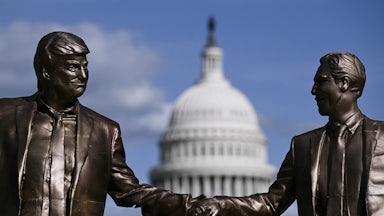 A statue of Donald Trump and Jeffrey Epstein holding hands stands in front of the Capitol