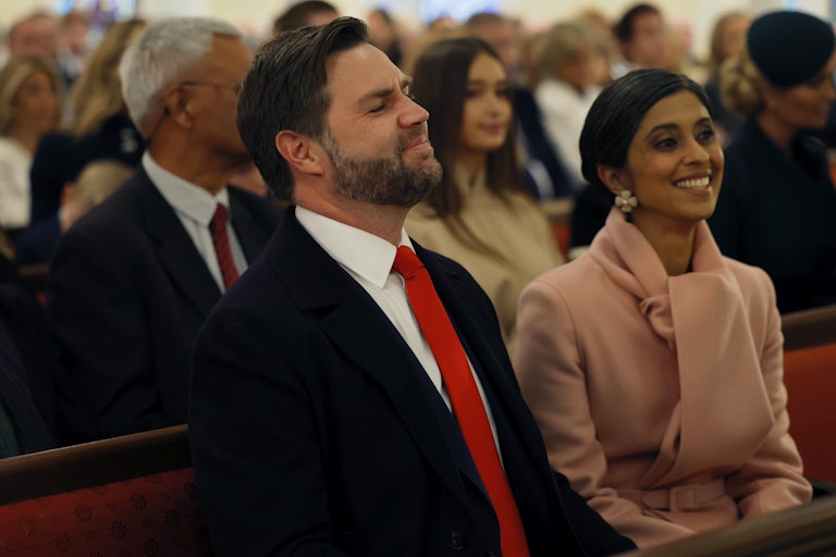 JD Vance and Usha Vance smile while seated in church. Vance's eyes are closed.