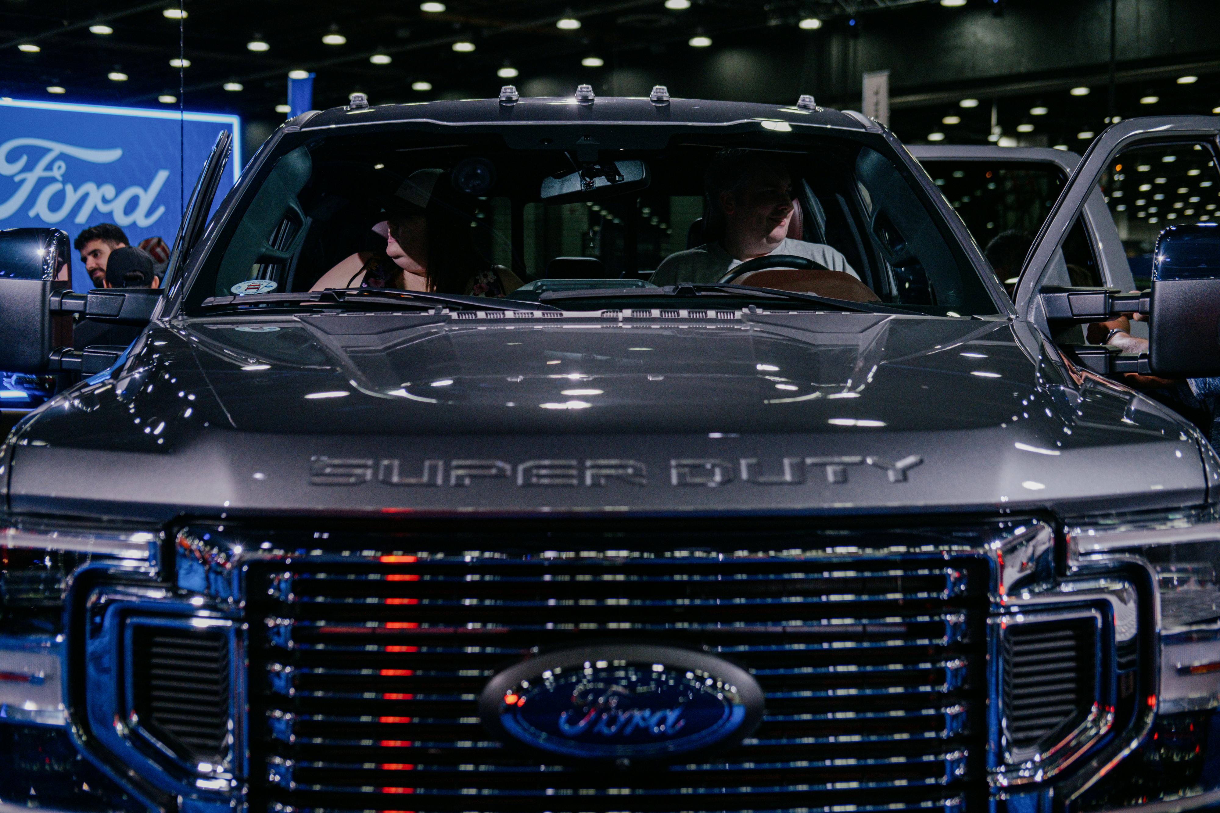 Two people sit in a large pickup truck.