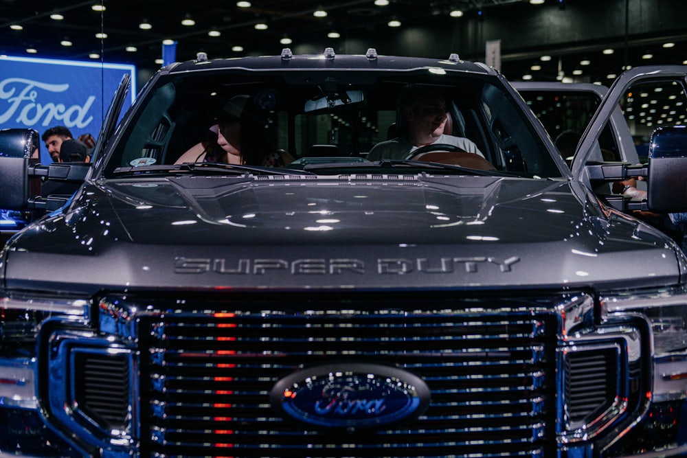 Two people sit in a large pickup truck.