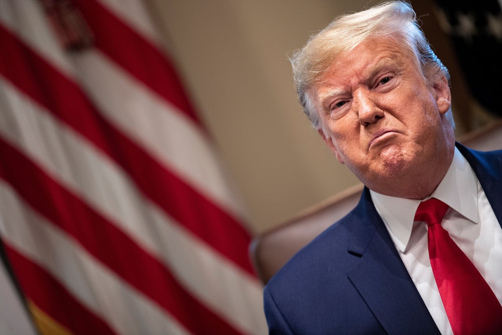 A scowling Donald Trump looks on at a White House meeting.