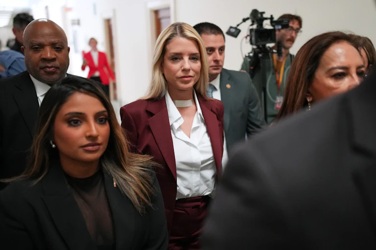Former Attorney General Pam Bondi walks among a crowd of people