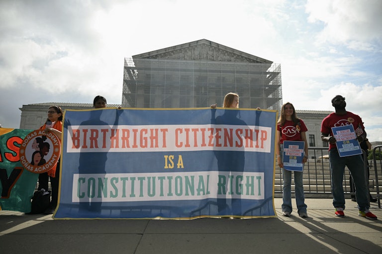 People hold up a banner that says, "Birthright citizenship is a constitutional right" at a protest outside the Supreme Court
