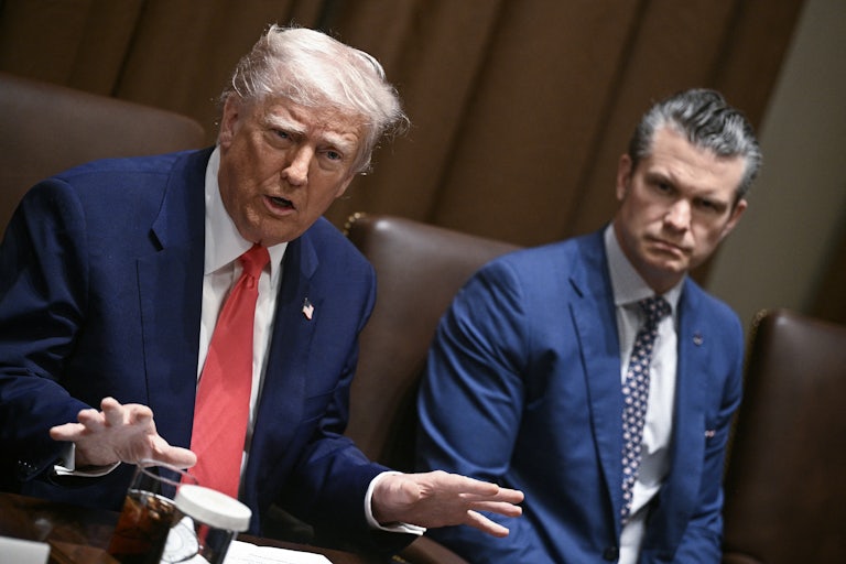 Donald Trump speaks animatedly as Defense Secretary Pete Hegeth look on. They’re all seated around a table for a Cabinet meeting.