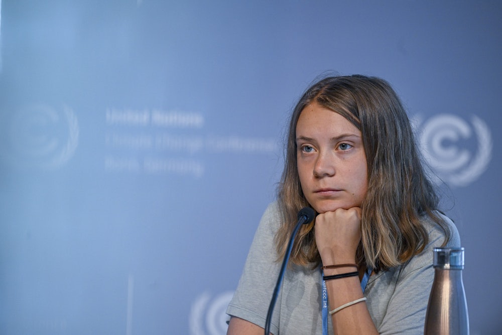 Greta Thunberg leans her head on her hand.