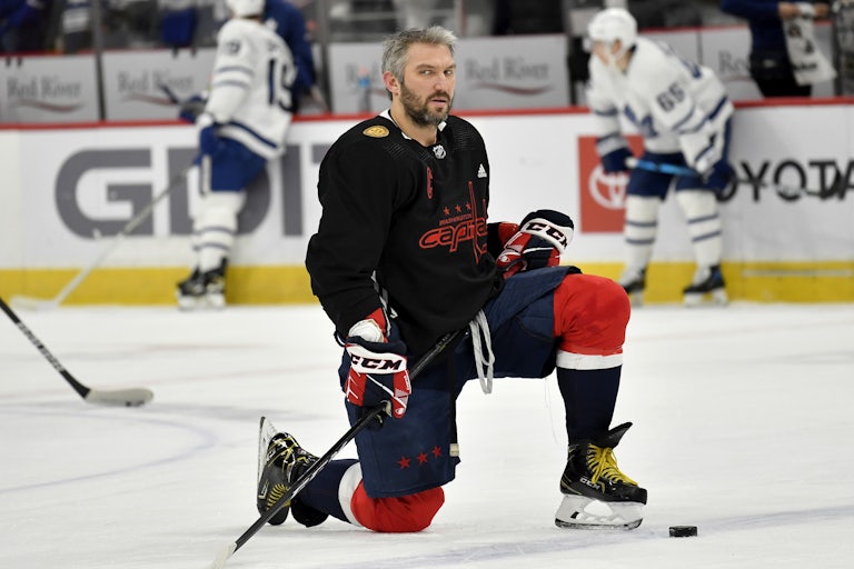 Washington Capitols player Alex Ovechkin kneels on one knee at center ice.