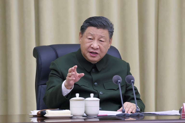 Chinese President Xi Jinping delivers a speech while seated at a table.