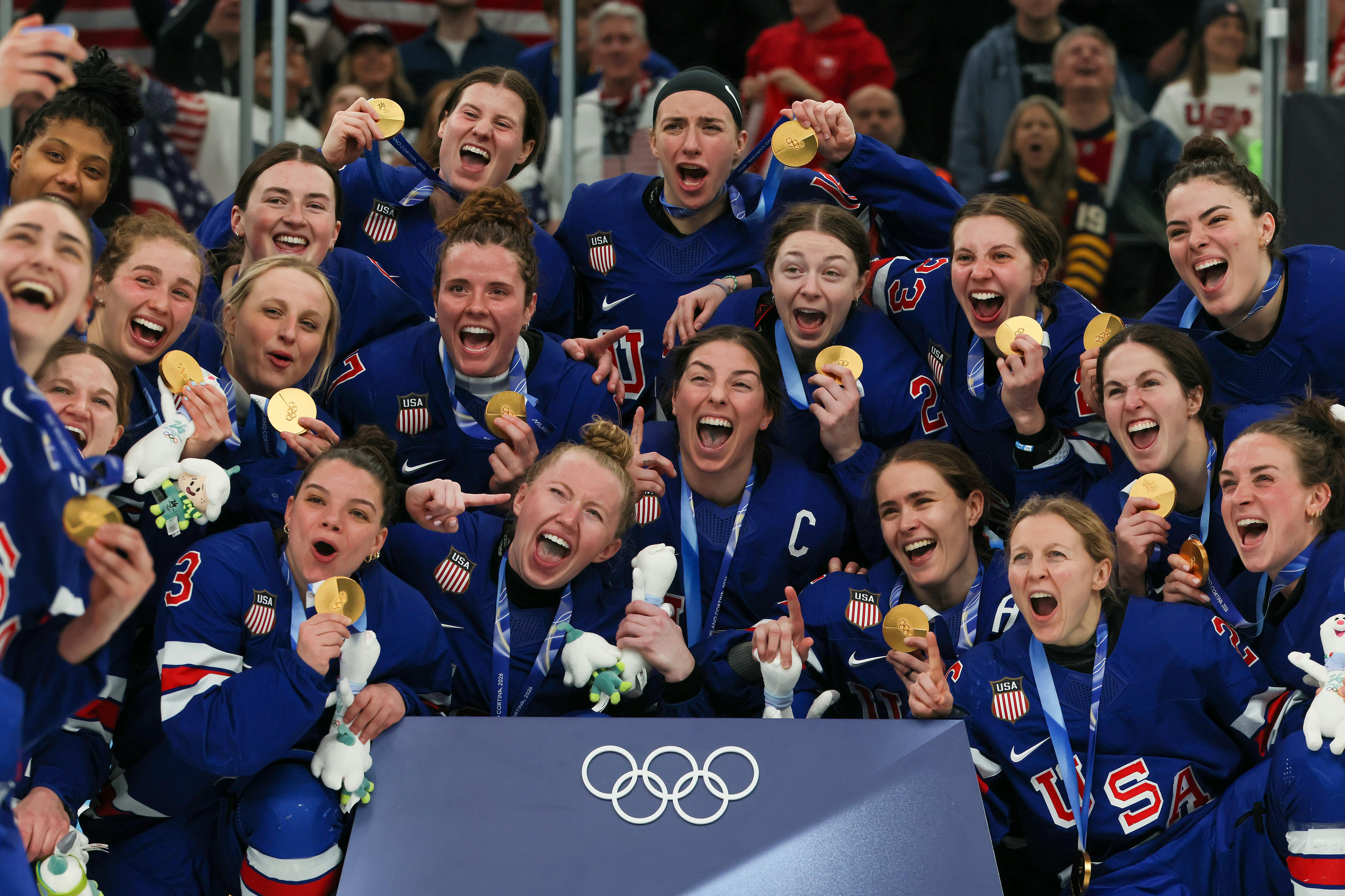 The U.S. women's hockey team poses with their gold medals at the Milan Olympics