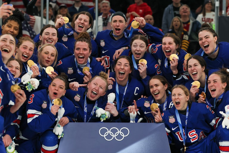 The U.S. women's hockey team poses with their gold medals at the Milan Olympics