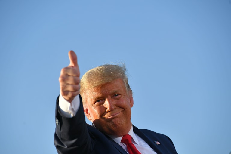 Trump gives a thumbs up sign as he leaves a rally.