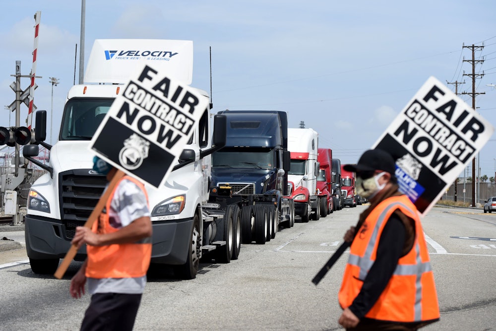 Two people carry signs saying "fair contract now."