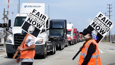 Two people carry signs saying "fair contract now."